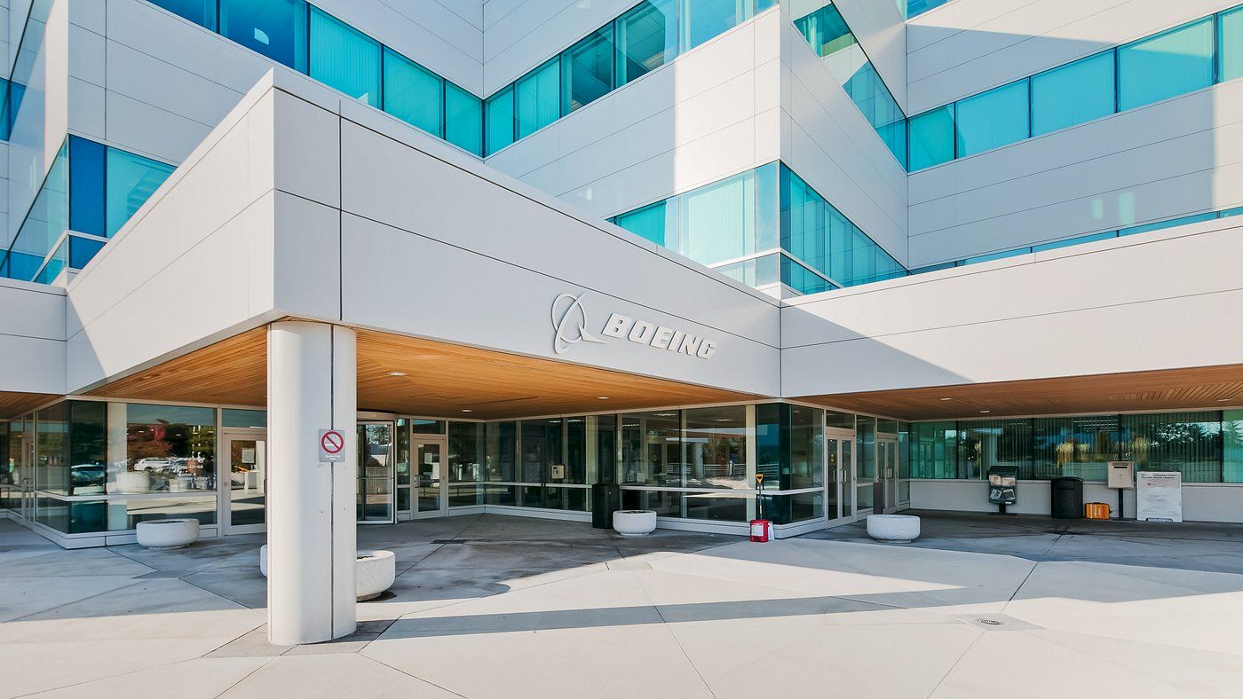 The image shows the entrance to a modern commercial building with "Boeing" prominently displayed above the entrance.